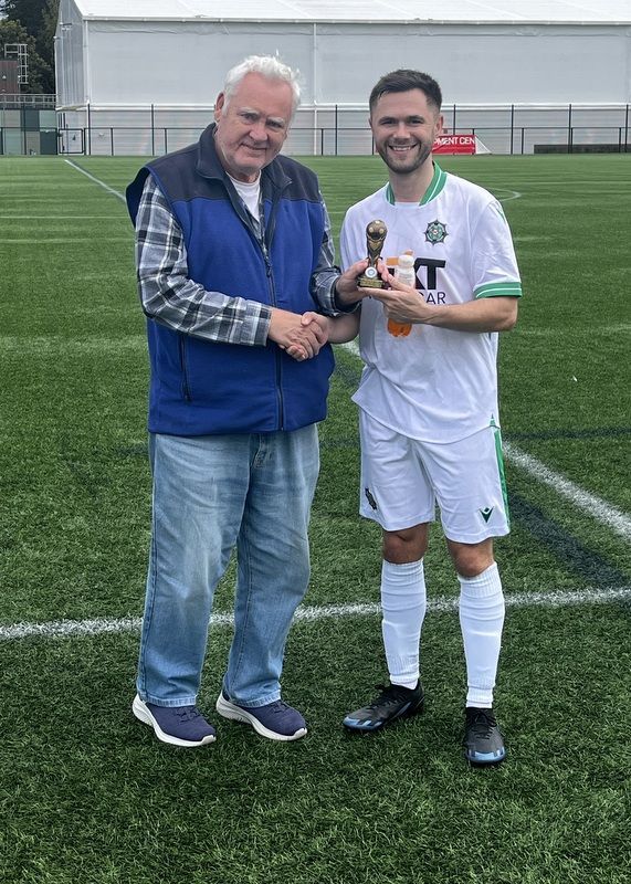 2026 McAleavey Cup !man of the Match! winner Aaron Dunlop receiving his trophy from League Secretary