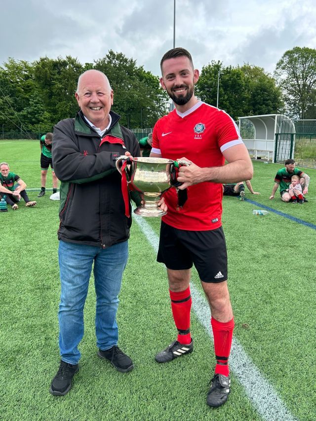 Phil Neill receiving the McAleavey Cup from League Chairman Alan McCline on behalf of Armagh & Down